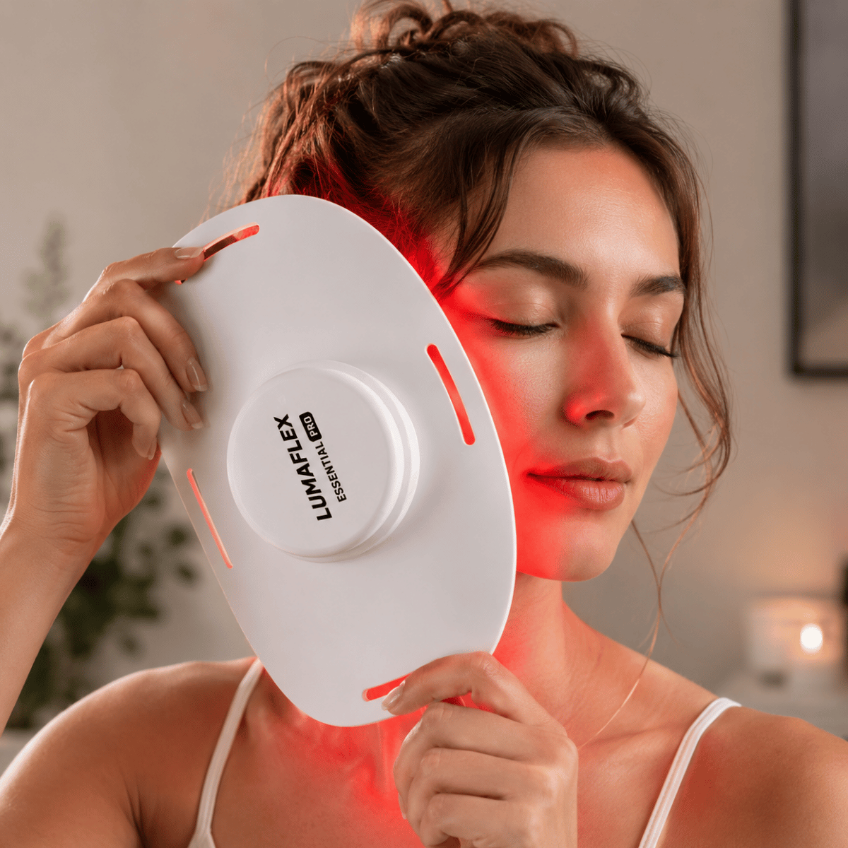 Woman using a red light therapy device on her face